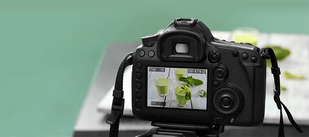 digital camera with viewfinder showing green smoothies on a table
