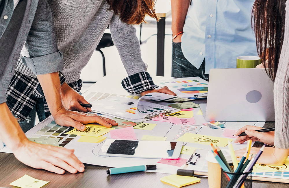 Group standing around notes on brand strategy