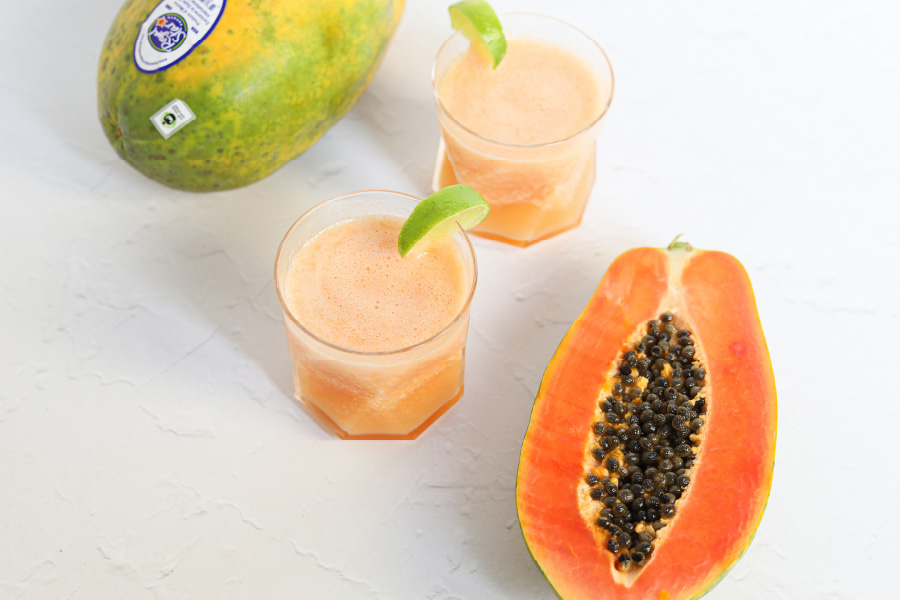 Image of papaya margarita with whole and cut papaya