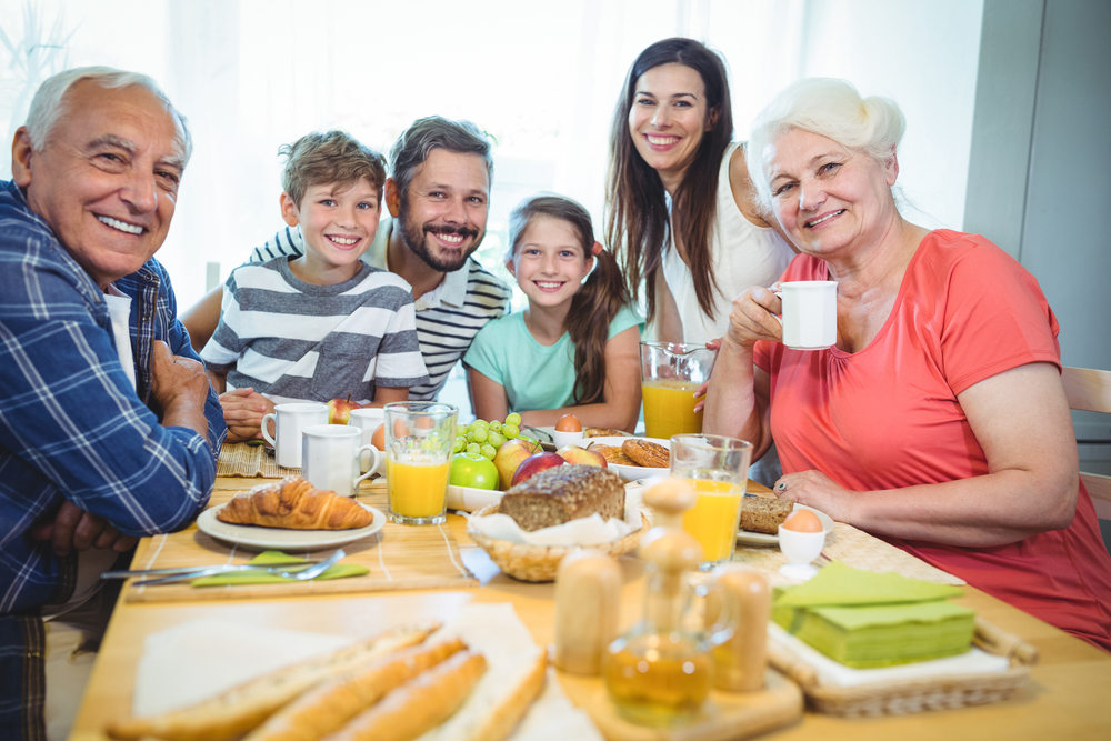 Portrait of happy multi-generation family sitting at breakfast table in home