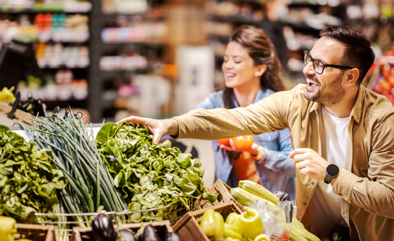 Happy couple shopping for fresh produce in grocery store